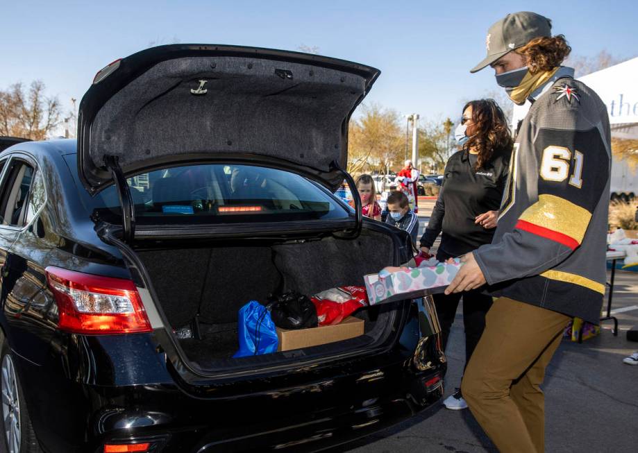 Golden Knights player Mark Stone loads up gifts during the first NLVPD Holiday Toy Giveaway dri ...