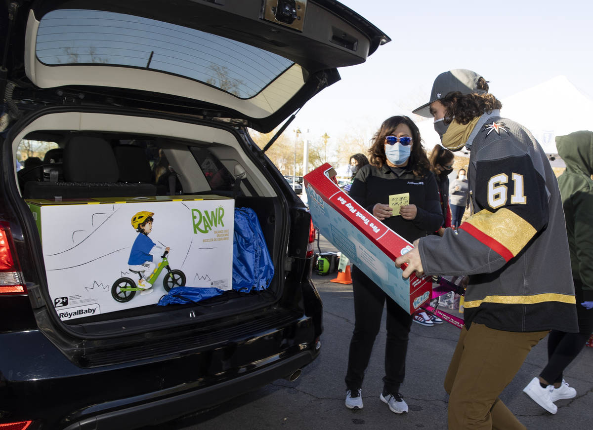 Golden Knights player Mark Stone loads up gifts during the first NLVPD Holiday Toy Giveaway dri ...