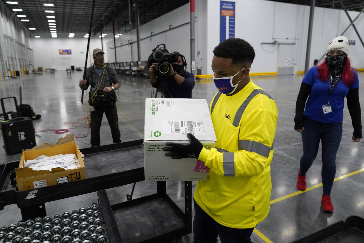 Boxes containing the Moderna COVID-19 vaccine are prepared to be shipped at the McKesson distri ...