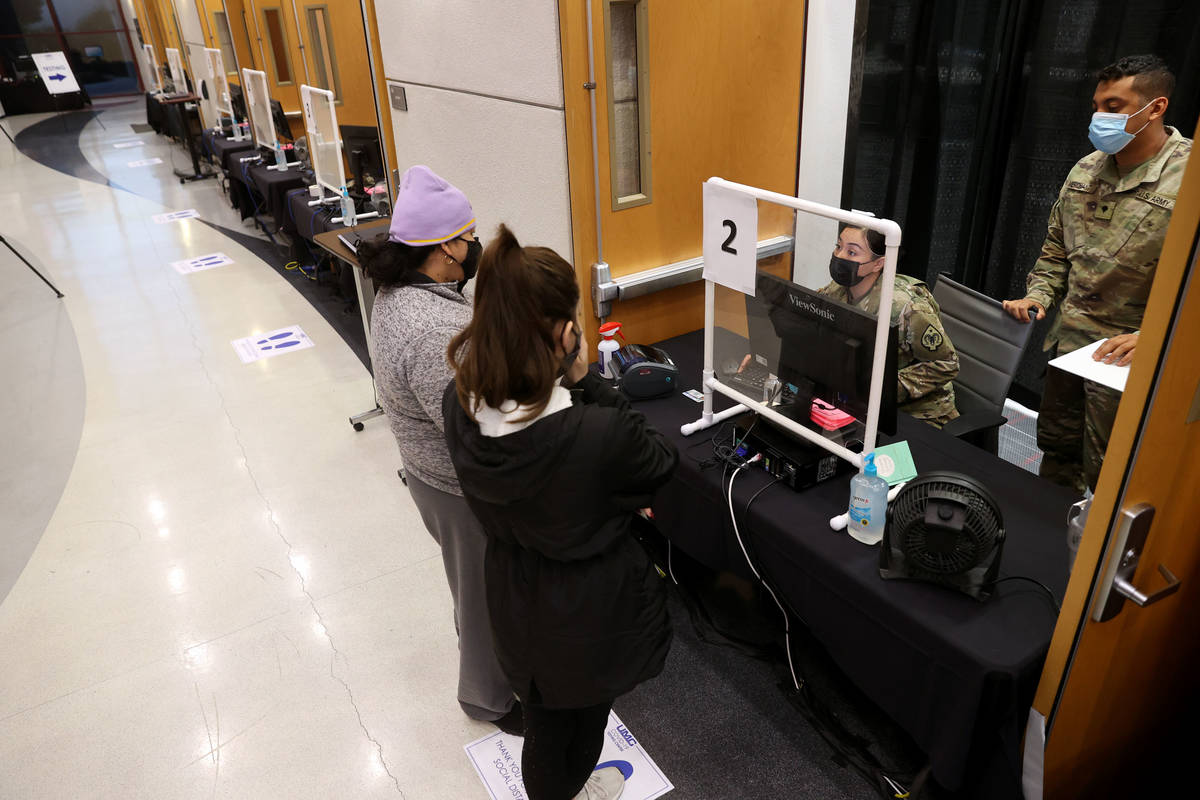 Nevada National Guard specialists Alondra Felix and Daniel Merchant check in Ana Pena, left, an ...