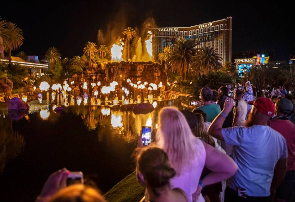 People on the Strip watch the first volcano show since the reopening of the The Mirage earlier ...