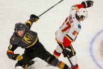 Vegas Golden Knights center Cody Glass (9, left) is takes dow by Calgary Flames right wing Mich ...