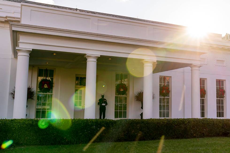 A Marine stands outside the entrance to the West Wing of the White House, signifying the Presid ...