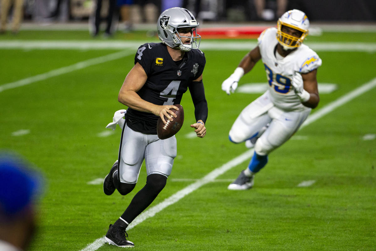 Raiders quarterback Derek Carr (4) scrambles with the football as Los Angeles Chargers cornerba ...