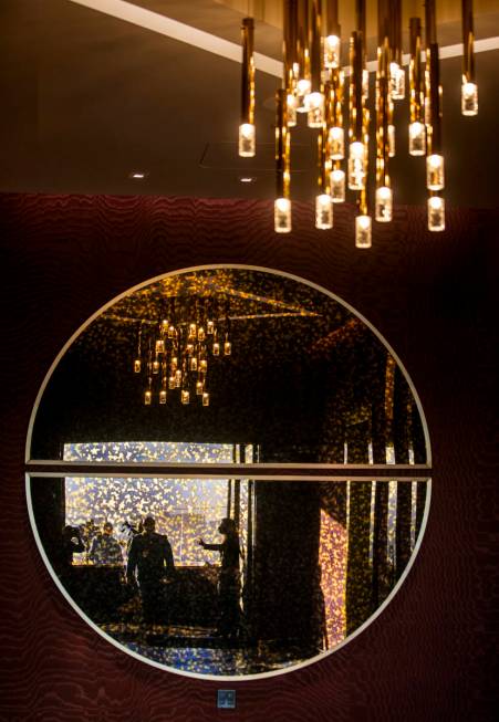 Visitors are reflected in a decorative mirror within the Legacy Club at Circa on Tuesday, Dec. ...