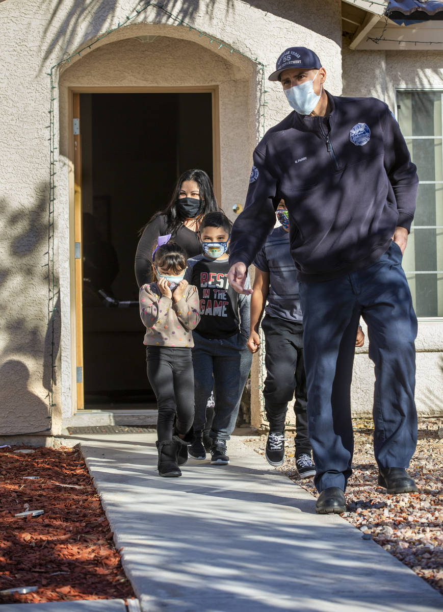 North Las Vegas Fire Truck 52 firefighter Brandon Parry, right, leads mom Laura Alicea, from to ...