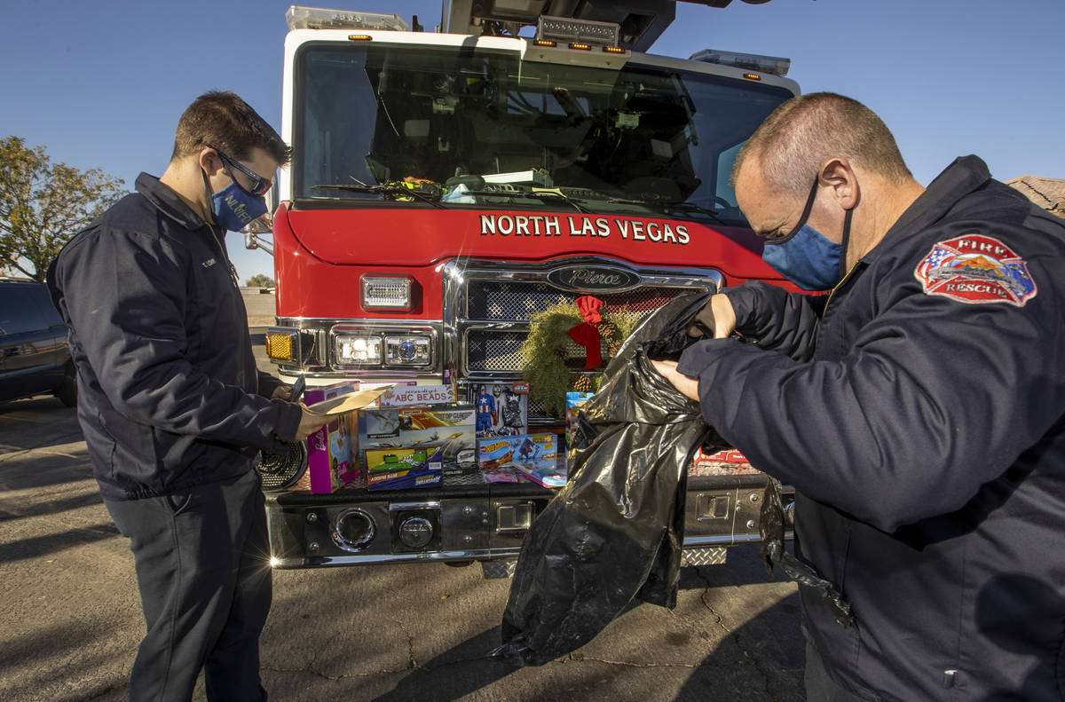 North Las Vegas Fire Truck 52 crew members Tyler Lowry, left, and Reese Williams arrange presen ...