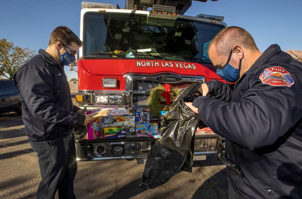 North Las Vegas Fire Truck 52 crew members Tyler Lowry, left, and Reese Williams arrange presen ...