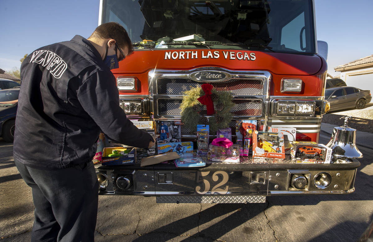North Las Vegas Fire Truck 52 crew member Tyler Lowry arranges presents atop the front bumper o ...