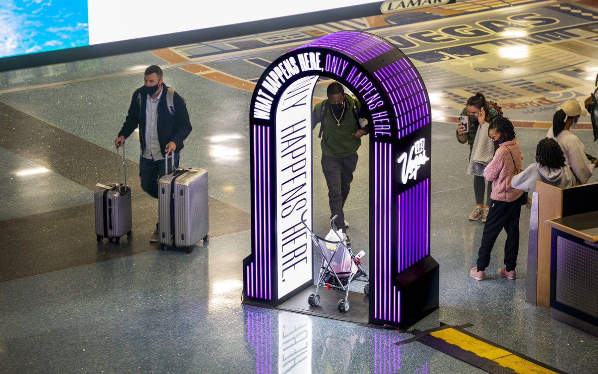 Visitors stop for a quick photo as arrivals continue at baggage in Terminal 1 during holiday tr ...