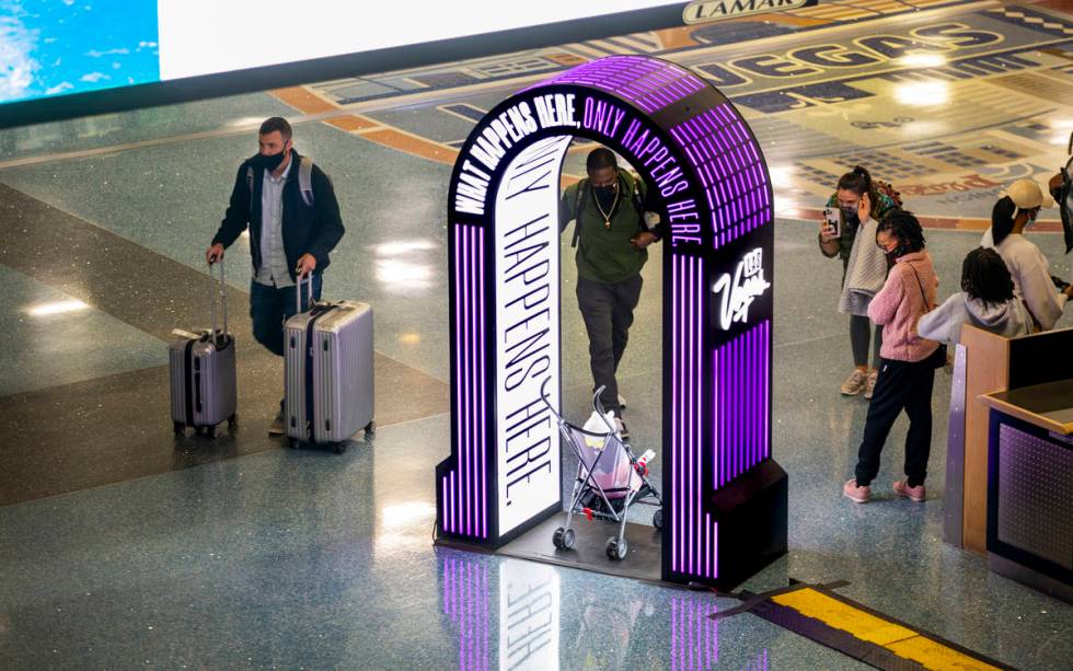 Visitors stop for a quick photo as arrivals continue at baggage in Terminal 1 during holiday tr ...