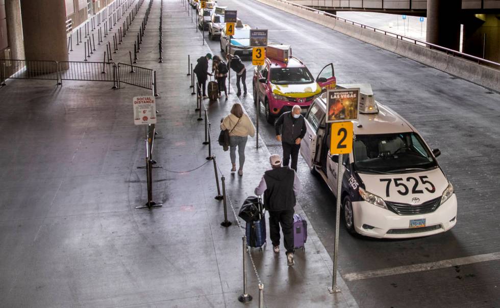 Travelers catch cabs outside Terminal 1 during holiday travel at McCarran International Airport ...