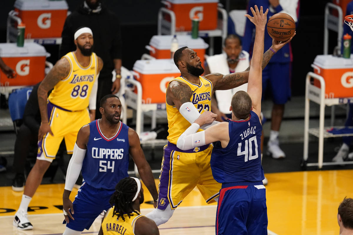 Los Angeles Lakers forward LeBron James, top, drives to the basket against the Los Angeles Clip ...