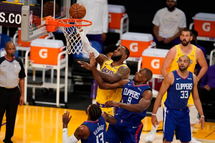 Los Angeles Lakers forward LeBron James, top, drives to the basket over Los Angeles Clippers ce ...