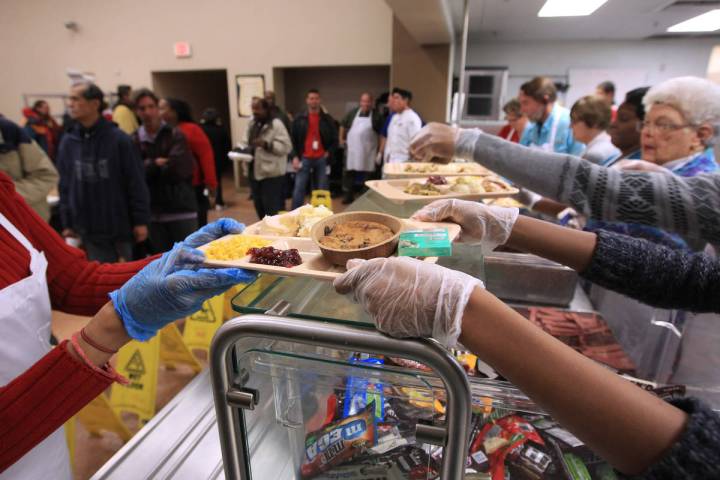 In this Dec. 24, 2014, file photo, volunteers serve up trays of turkey and all the trimmings du ...