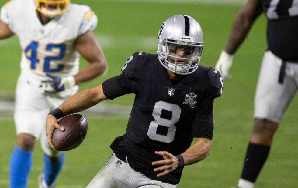 Raiders quarterback Marcus Mariota (8) scrambles past Los Angeles Chargers linebacker Uchenna N ...