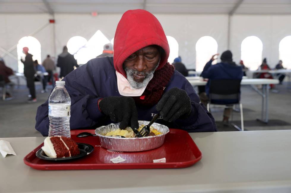 People, including Edward Wright, 69, eat a Christmas meal of prime rib with horseradish cream s ...