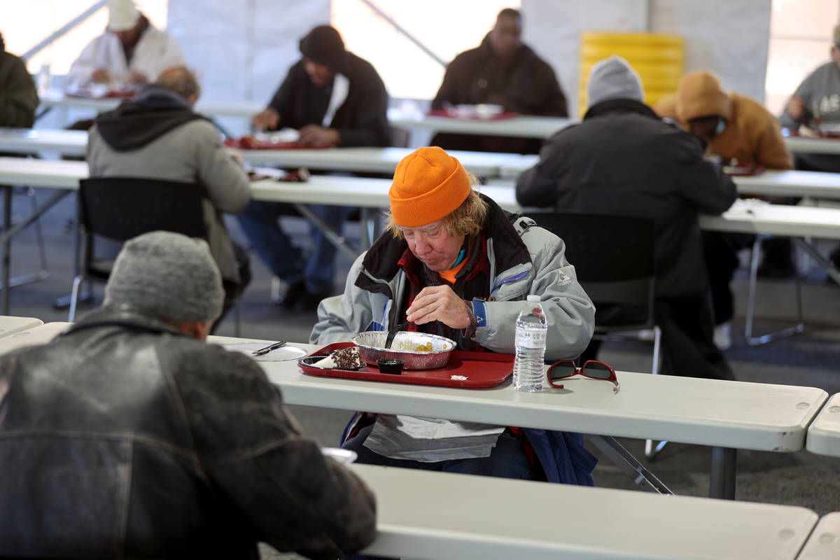 People, including Brian Van Fleet, 64, eat a Christmas meal of prime rib with horseradish cream ...