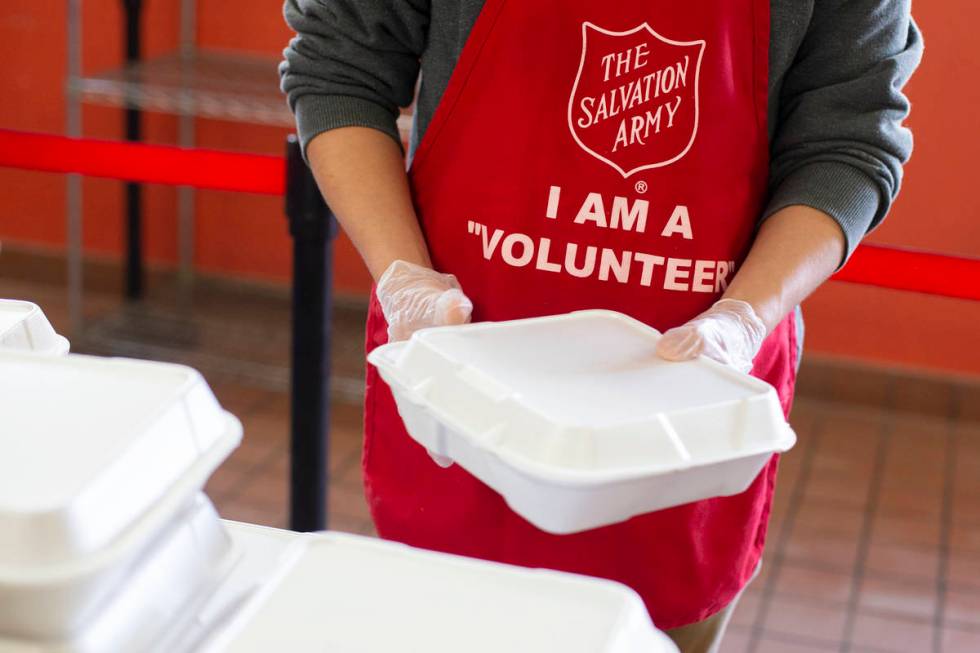 Reid Hightower, who came to volunteer with his family, hands out Christmas meals at The Salvati ...