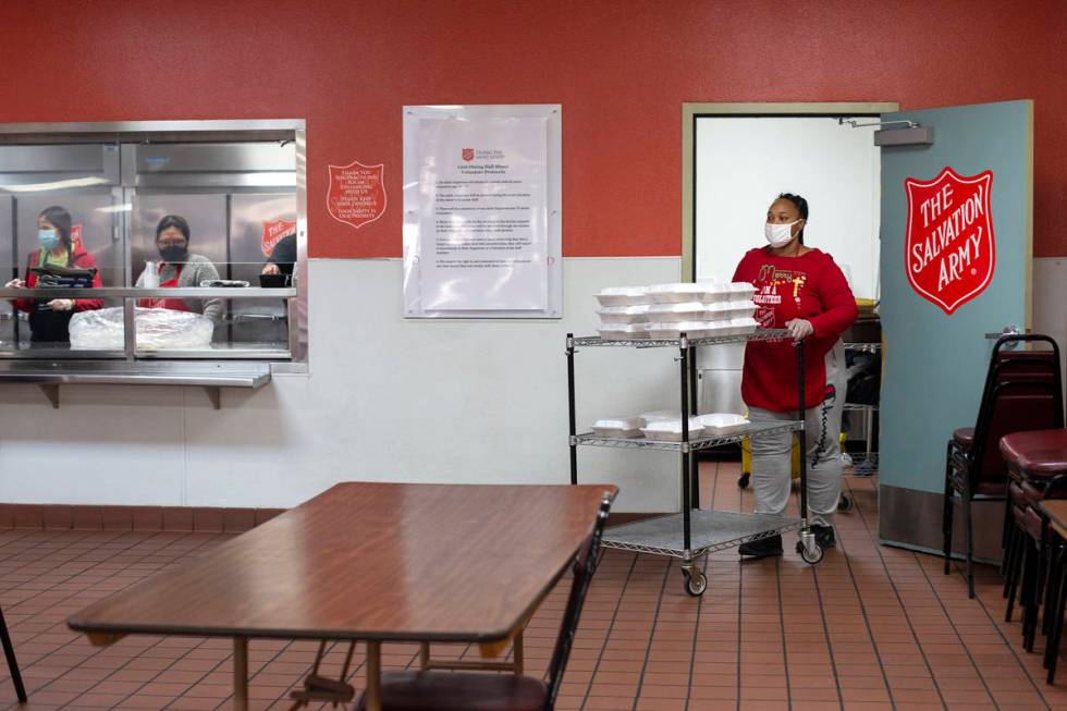 Jacqueline Moore, right, wheels Christmas meals from the kitchen to be handed out to their gues ...