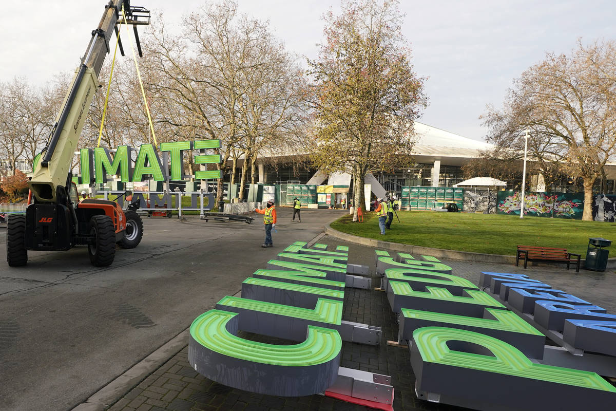 Workers assemble signs for the top of Climate Pledge Arena (shown in the background), the futur ...