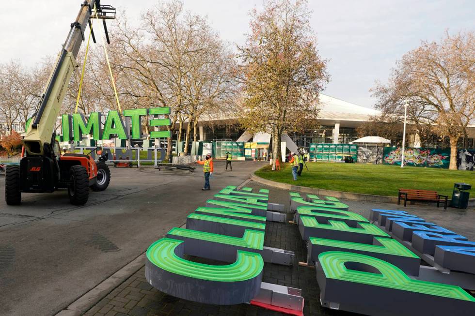 Workers assemble signs for the top of Climate Pledge Arena (shown in the background), the futur ...