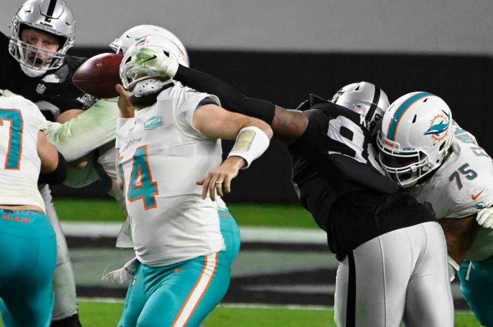 Las Vegas Raiders defensive end Arden Key (99) commits a roughing the passer penalty on Miami D ...