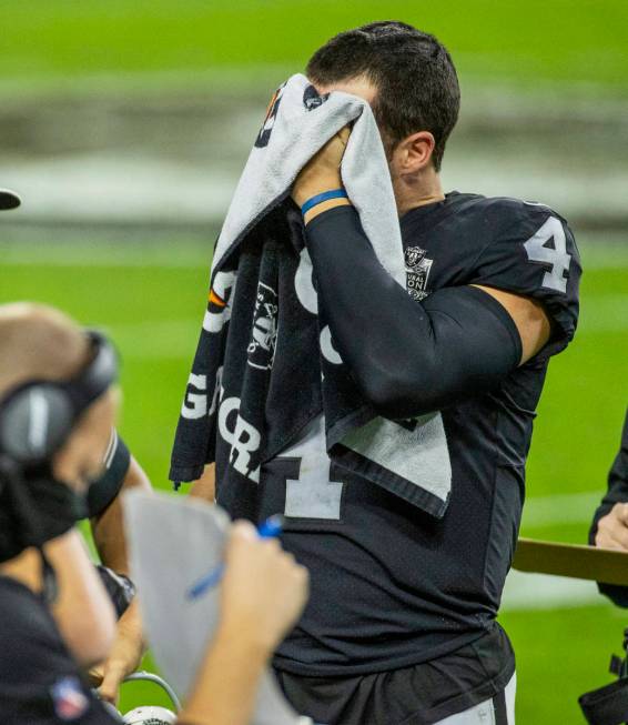 Raiders quarterback Derek Carr (4) puts a towel over his face on the sidelines versus the Miami ...