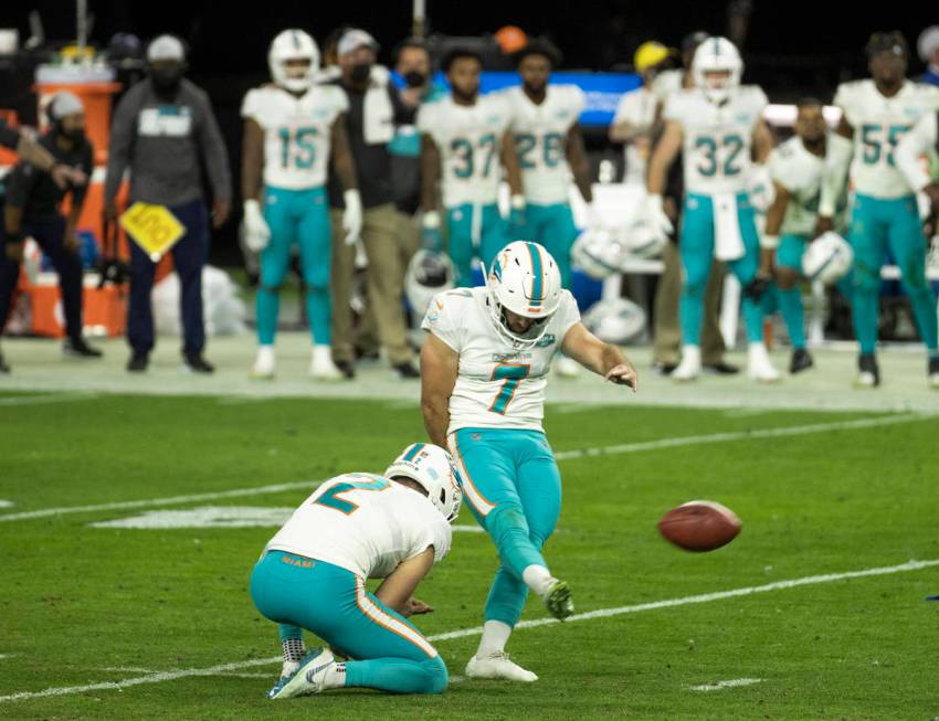 Miami Dolphins kicker Jason Sanders (7) kicks the winning extra point with a hold by teammate p ...