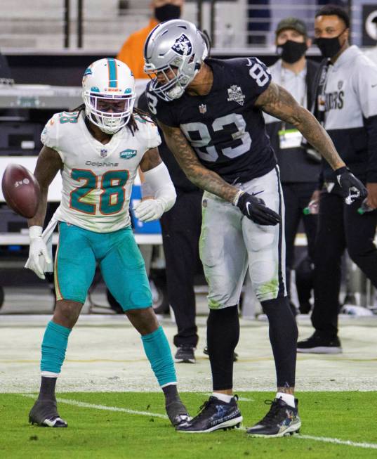 Raiders tight end Darren Waller (83) spikes the ball in the face of Miami Dolphins strong safet ...