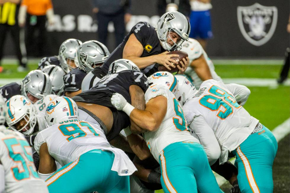 Raiders quarterback Derek Carr (4) goes over the top of the pile for a touchdown versus the Mia ...