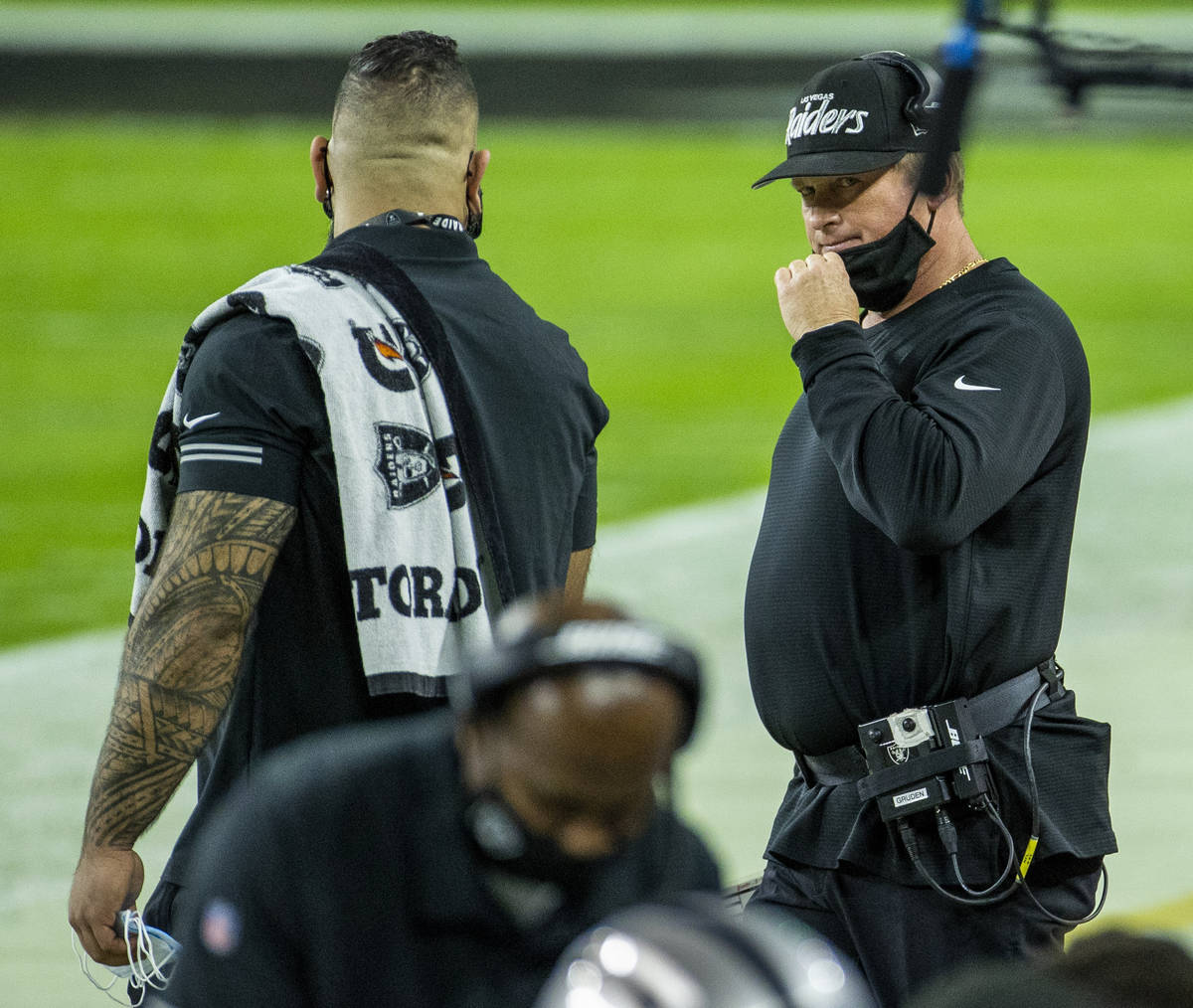 Raiders head coach Jon Gruden looks to another staff member on the sidelines versus the Miami D ...