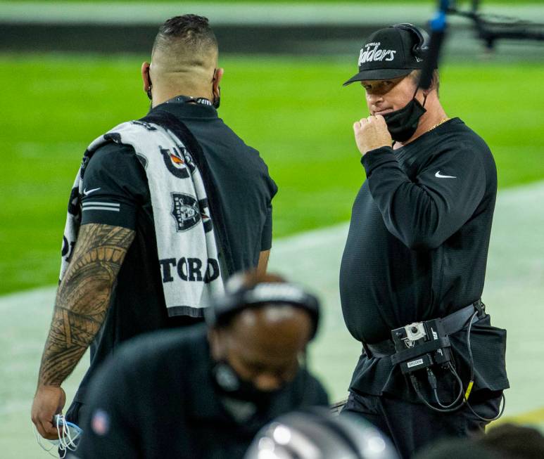 Raiders head coach Jon Gruden looks to another staff member on the sidelines versus the Miami D ...
