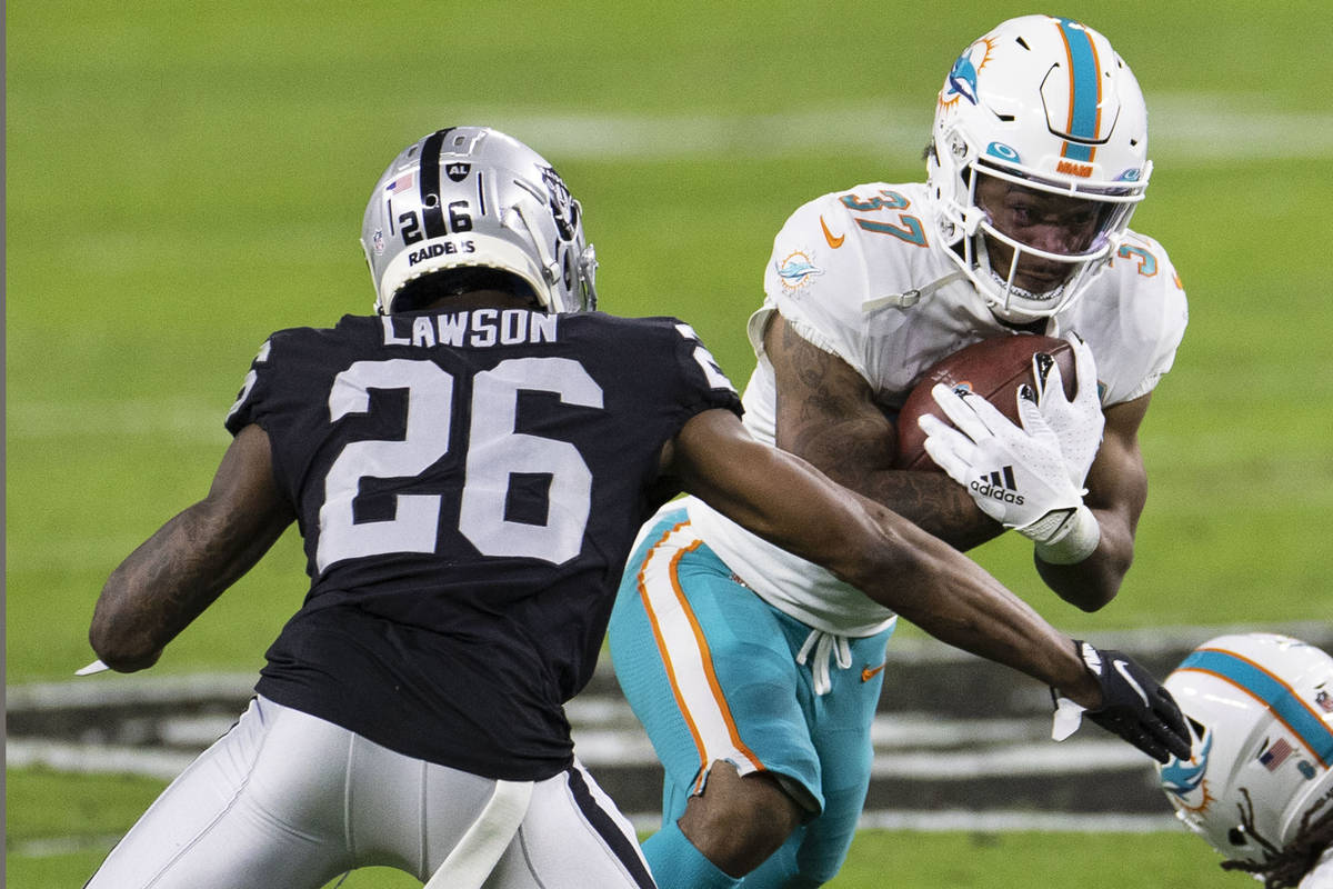 Raiders cornerback Nevin Lawson (26) defends Miami Dolphins running back Myles Gaskin (37) duri ...