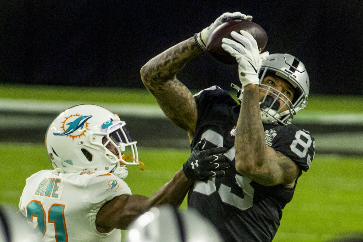 Raiders tight end Darren Waller (83) makes a long reception over Miami Dolphins free safety Eri ...
