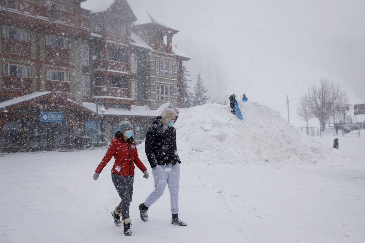 People walk through the snow in the village of Blue Mountain Ski Resort in The Blue Mountains, ...