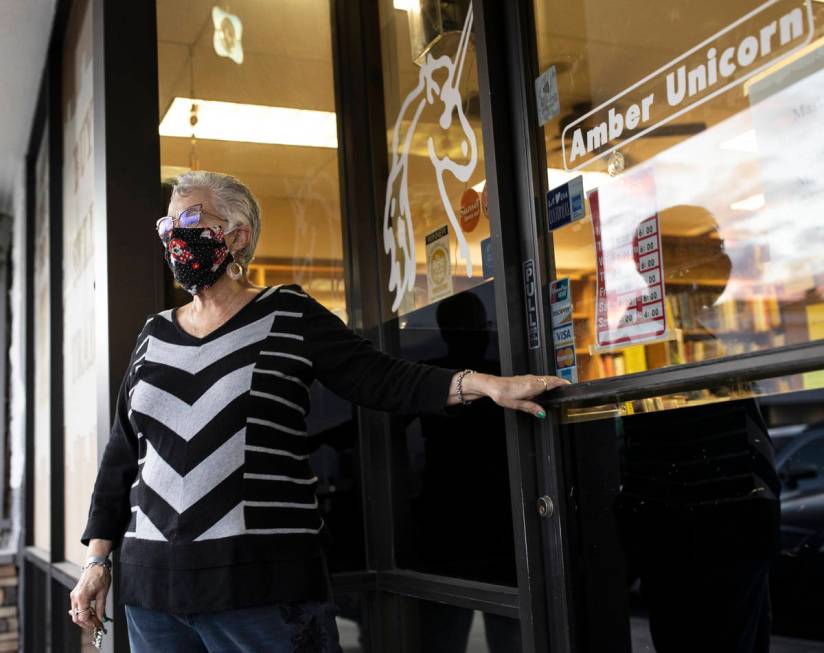 Myrna Donato, owner of Amber Unicorn Books, looks out at the sunset after locking the doors on ...