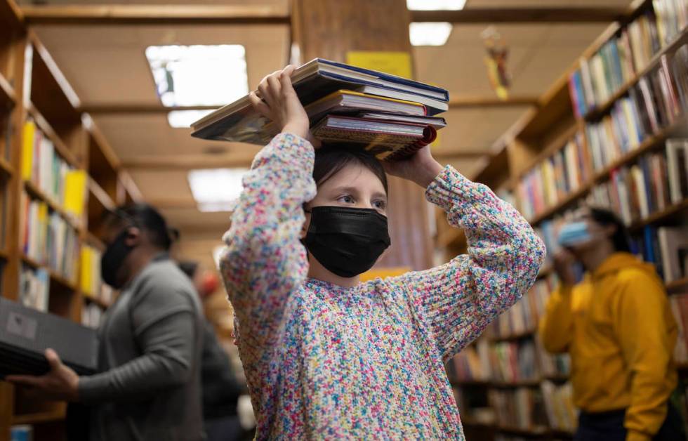 Era Kuka, 10, waits to check out at Amber Unicorn Books on the last business day of the Vegas l ...