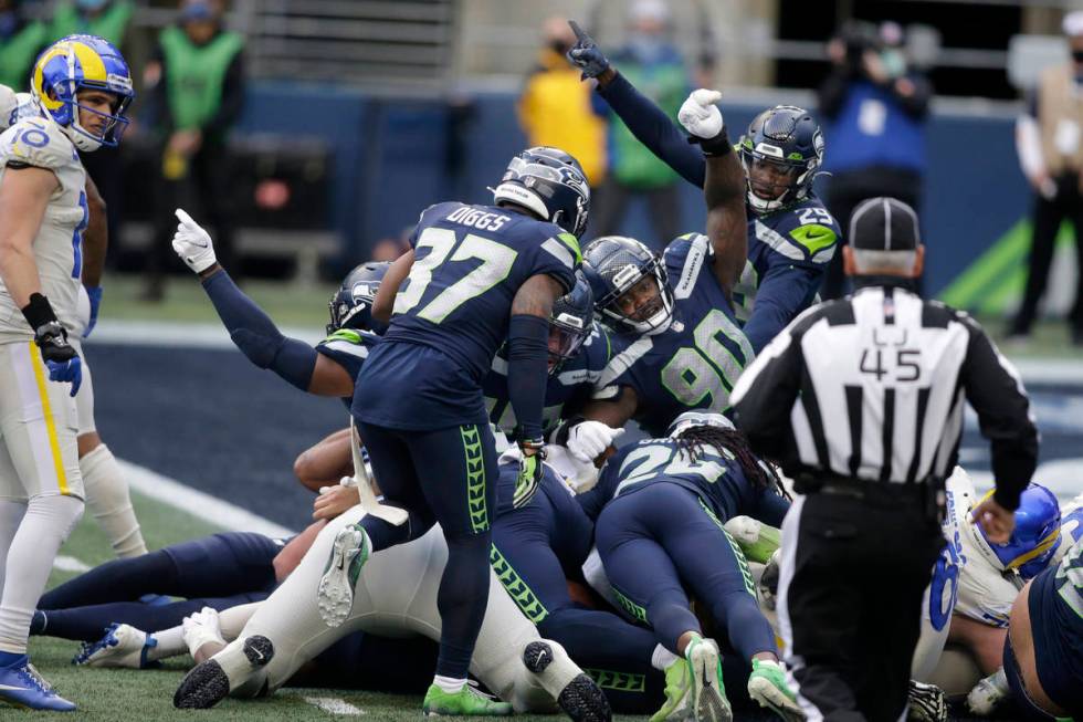 Seattle Seahawks players, including defensive tackle Jarran Reed (90) react after the Seahawks ...