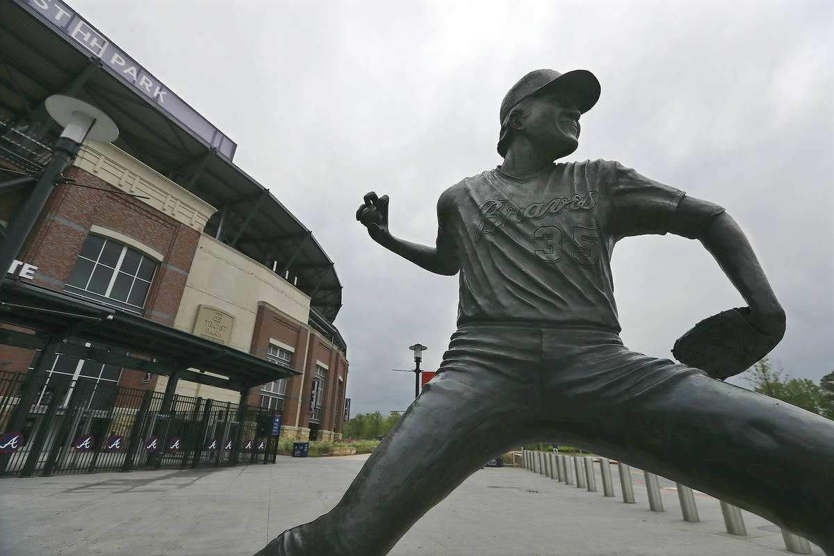 A statue of Atlanta Braves pitcher Phil Niekro stand outside Truist Park, home of baseball's At ...