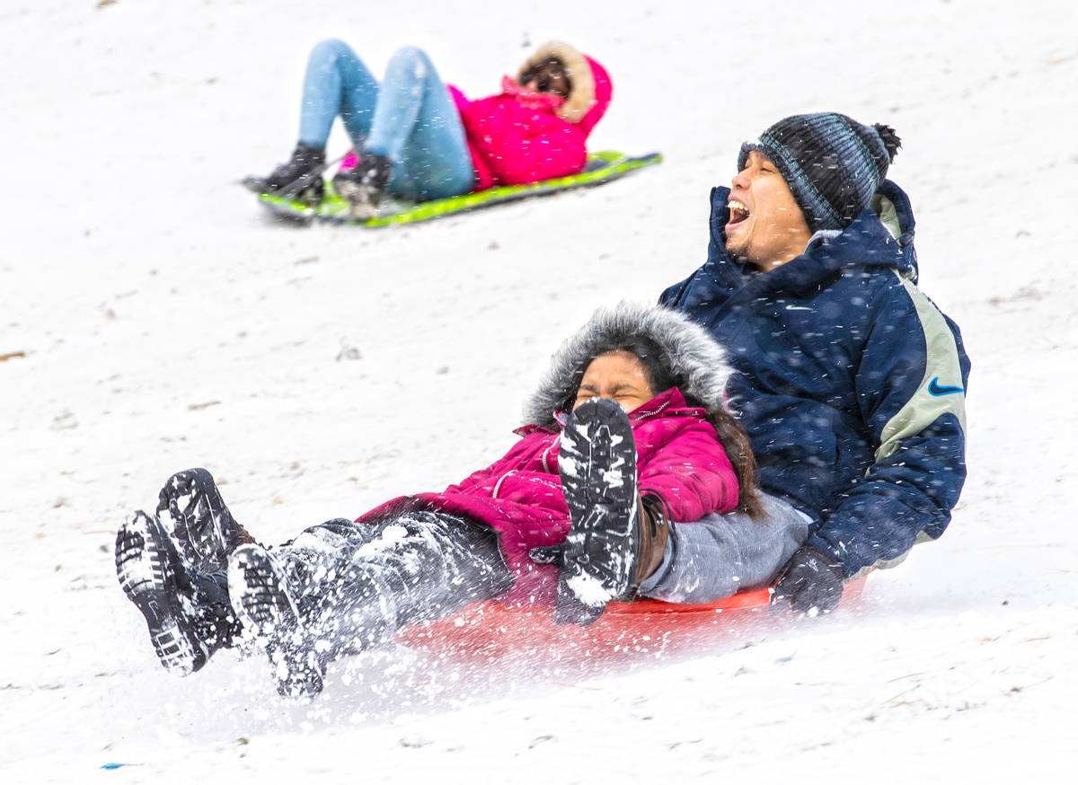 Vince Ortega, right, and daughter Shey, 10, sled down a hill at Lee Canyon on Monday, Dec. 28, ...