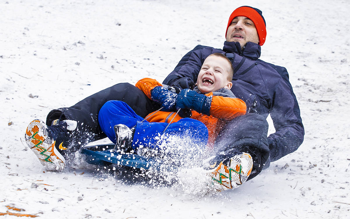 Yordan Yordanov, right, and son Alex, 6, sled down a hill at Lee Canyon on Monday, Dec. 28, 202 ...