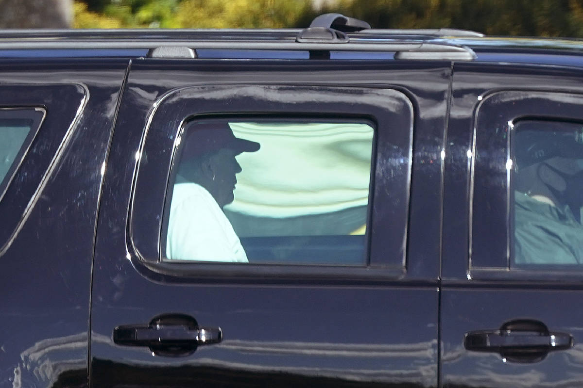 President Donald Trump rides in a motorcade vehicle as he departs Trump International Golf Club ...