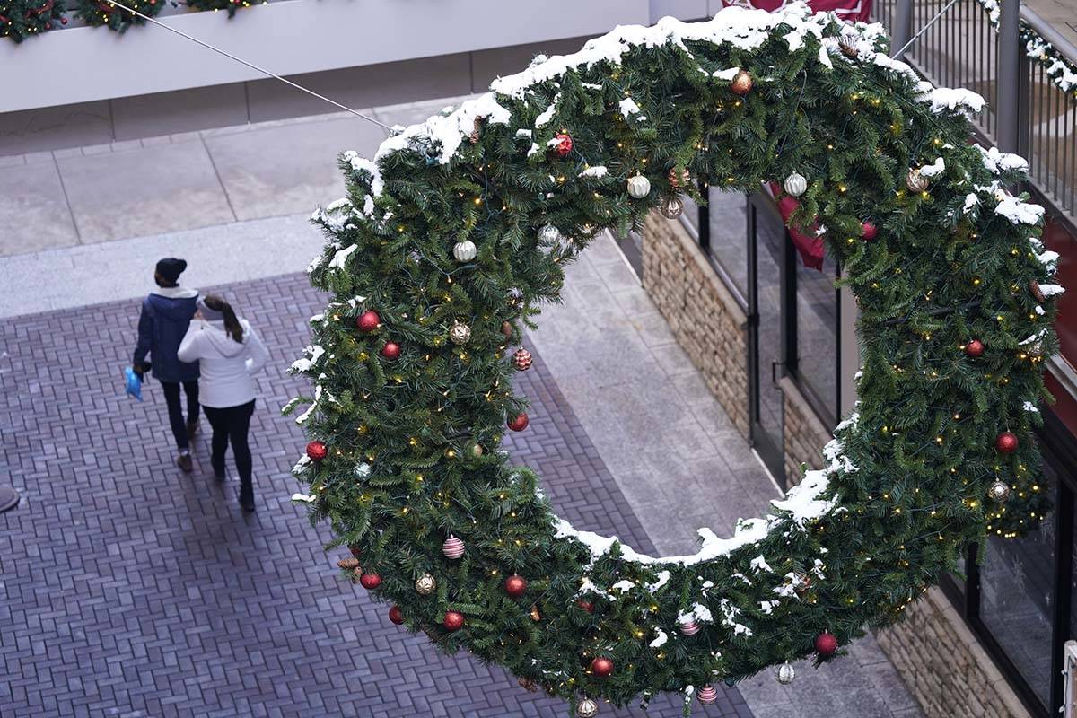 Shoppers wear face masks while in search of after-Christmas bargains in shops in the Denver Pav ...