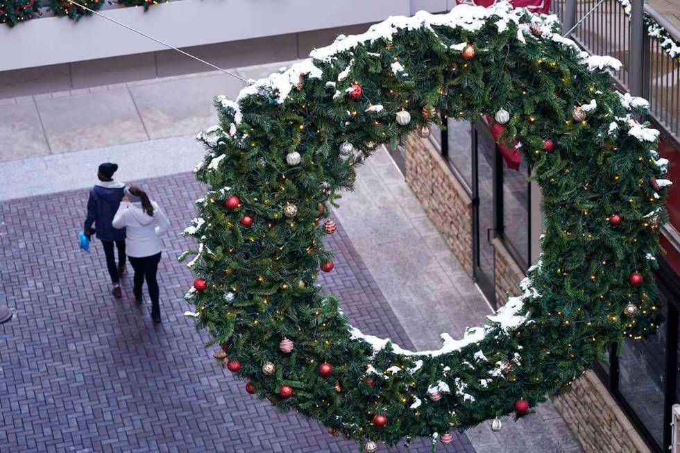 Shoppers wear face masks while in search of after-Christmas bargains in shops in the Denver Pav ...