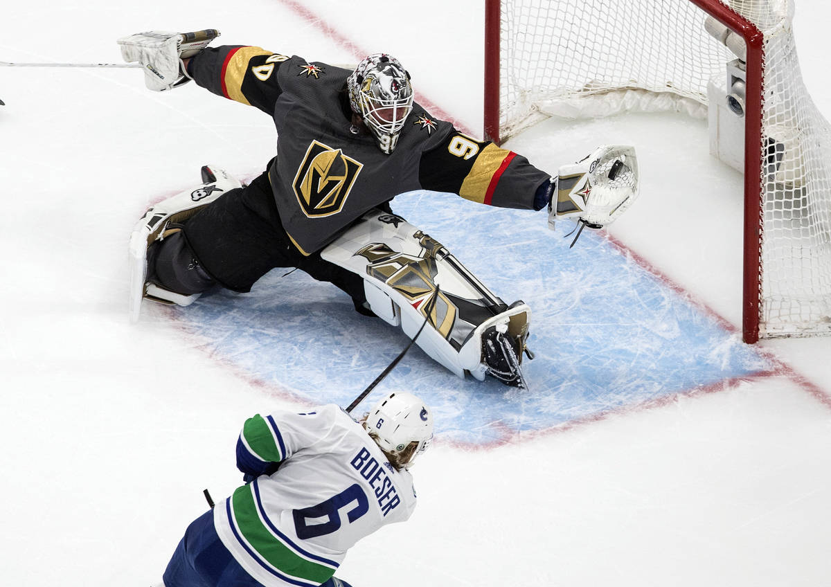 Vancouver Canucks' Brock Boeser (6) is stopped by Vegas Golden Knights goalie Robin Lehner (90) ...