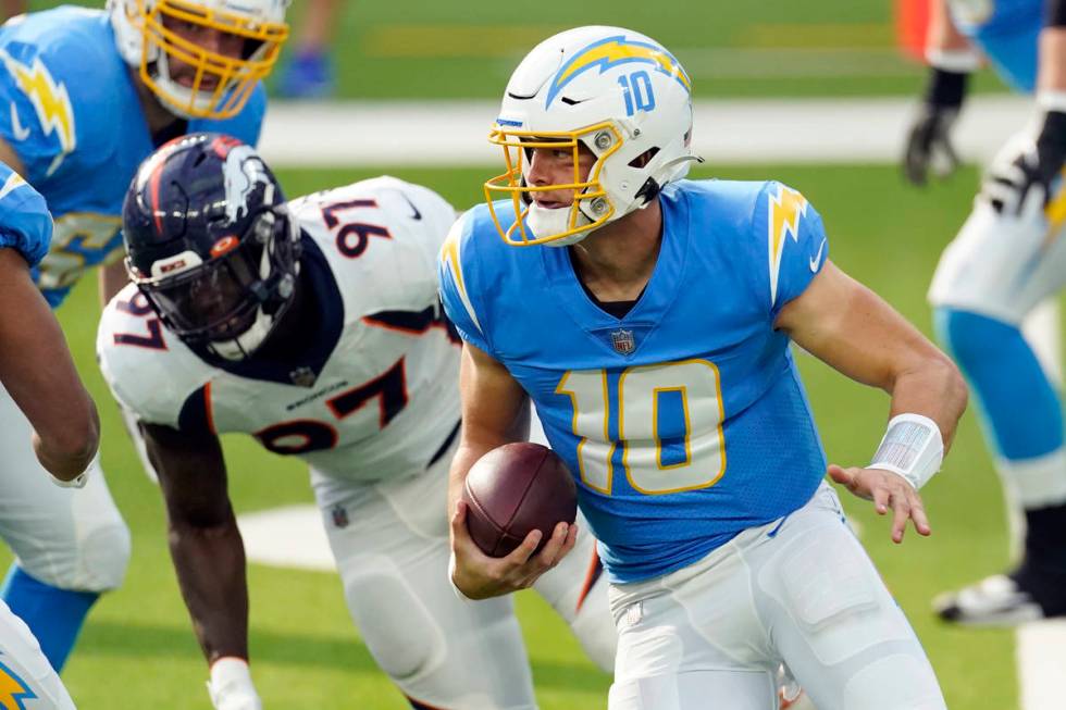 Los Angeles Chargers quarterback Justin Herbert (10) runs against the Denver Broncos during the ...