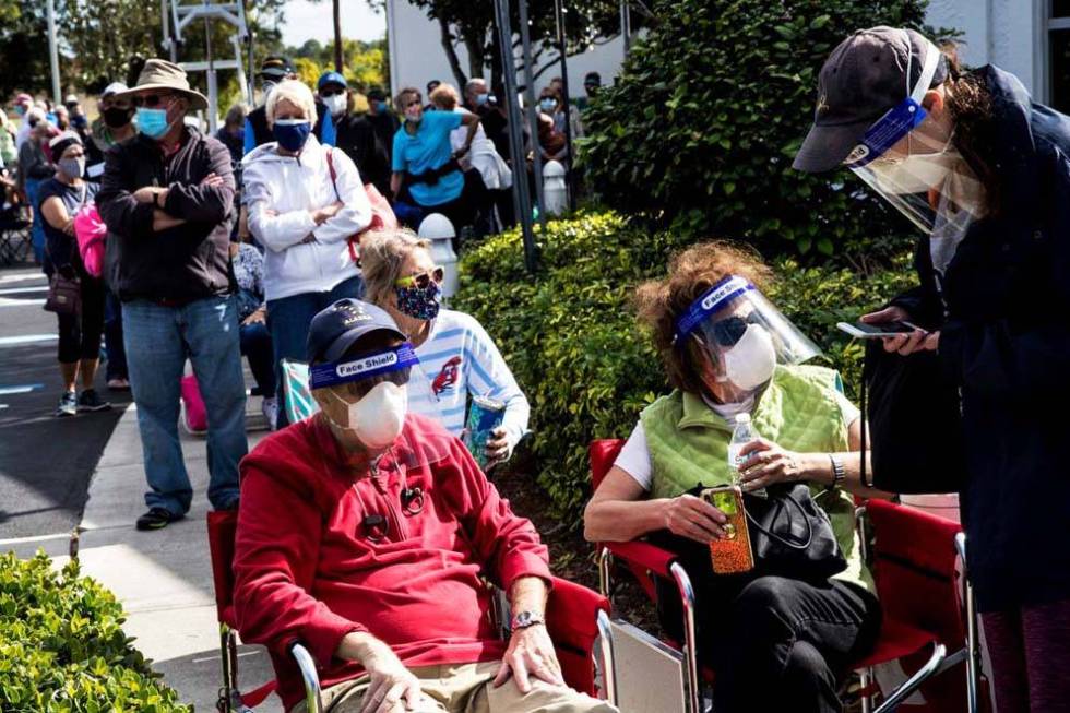 Joel and Susan Pittelman, from Naples, Fla., wait in line to receive COVID-19 vaccines on Tuesd ...