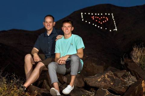David Koch, left, and son Mason sit on rocks at the trailhead below their Nevada light display ...