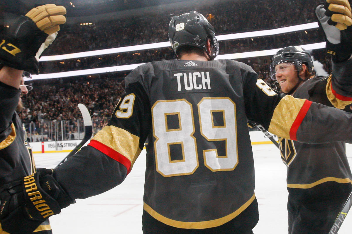 Golden Knights right wing Alex Tuch (89) celebrates his goal with Luca Sbisa, left, and Cody Ea ...